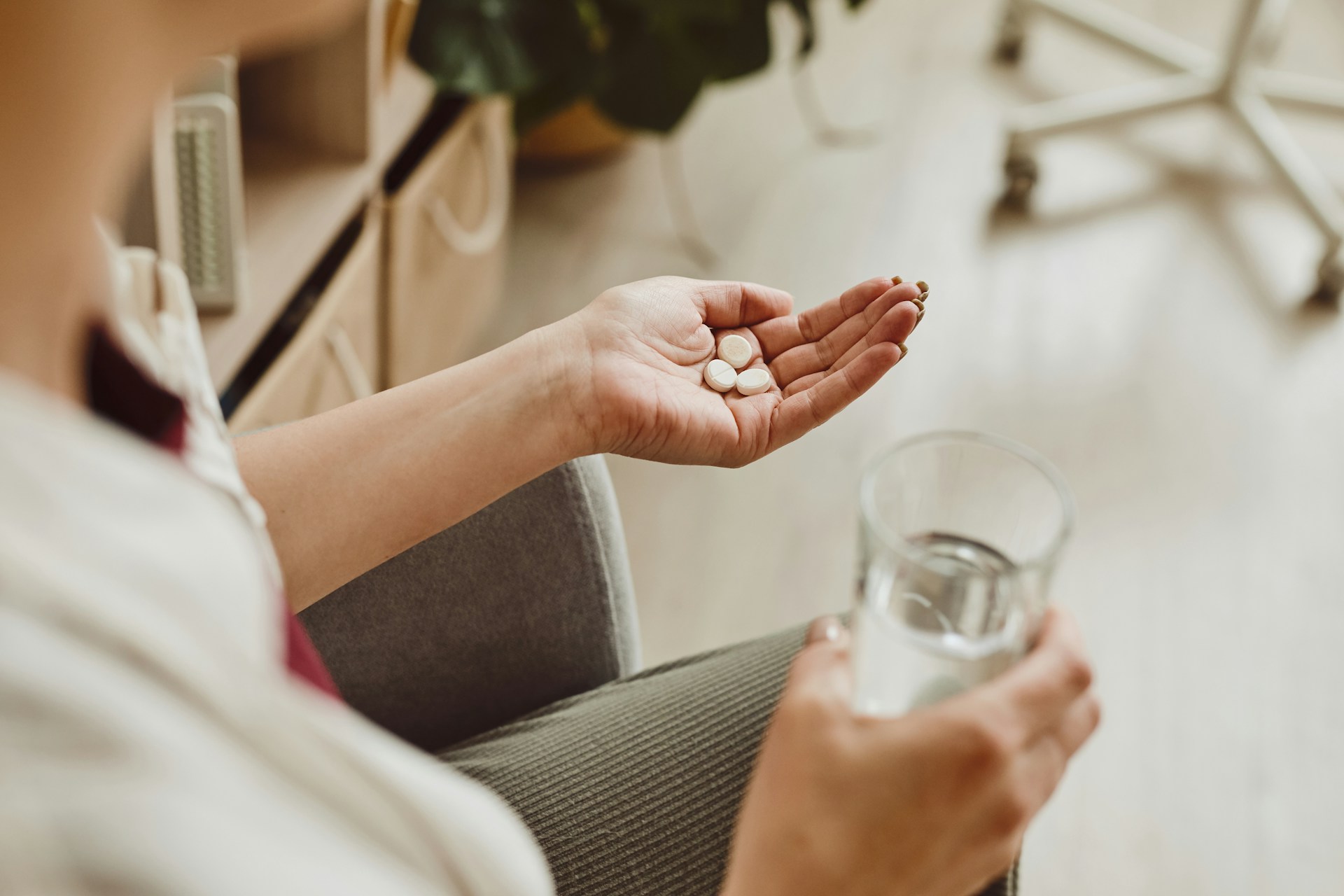 A person holding a blister pack of psychiatric medication pills in their hand, symbolizing mental health treatment and the potential side effects of psychiatric medications.