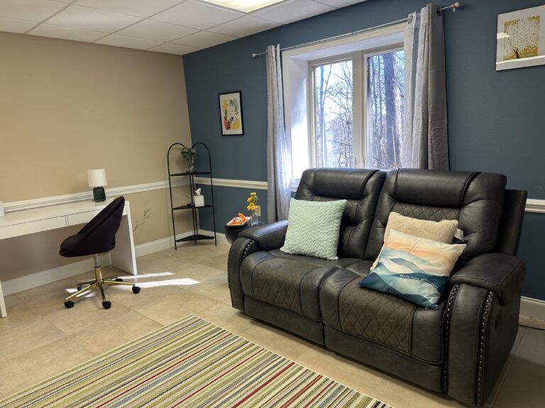 Two comfortable black leather reclining couches in the therapy room at Joy Spring Mental Health in Hendersonville, NC.