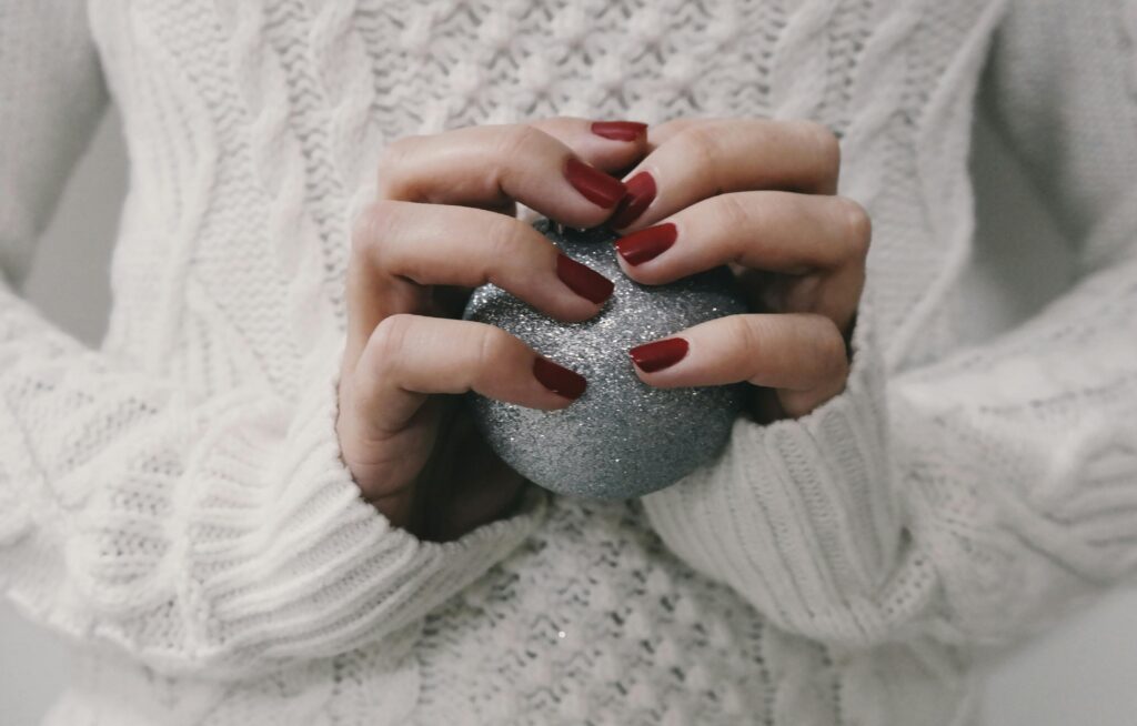 Person in a cozy winter setting resting quietly, symbolizing gentleness, emotional care, and reduced expectations during December.